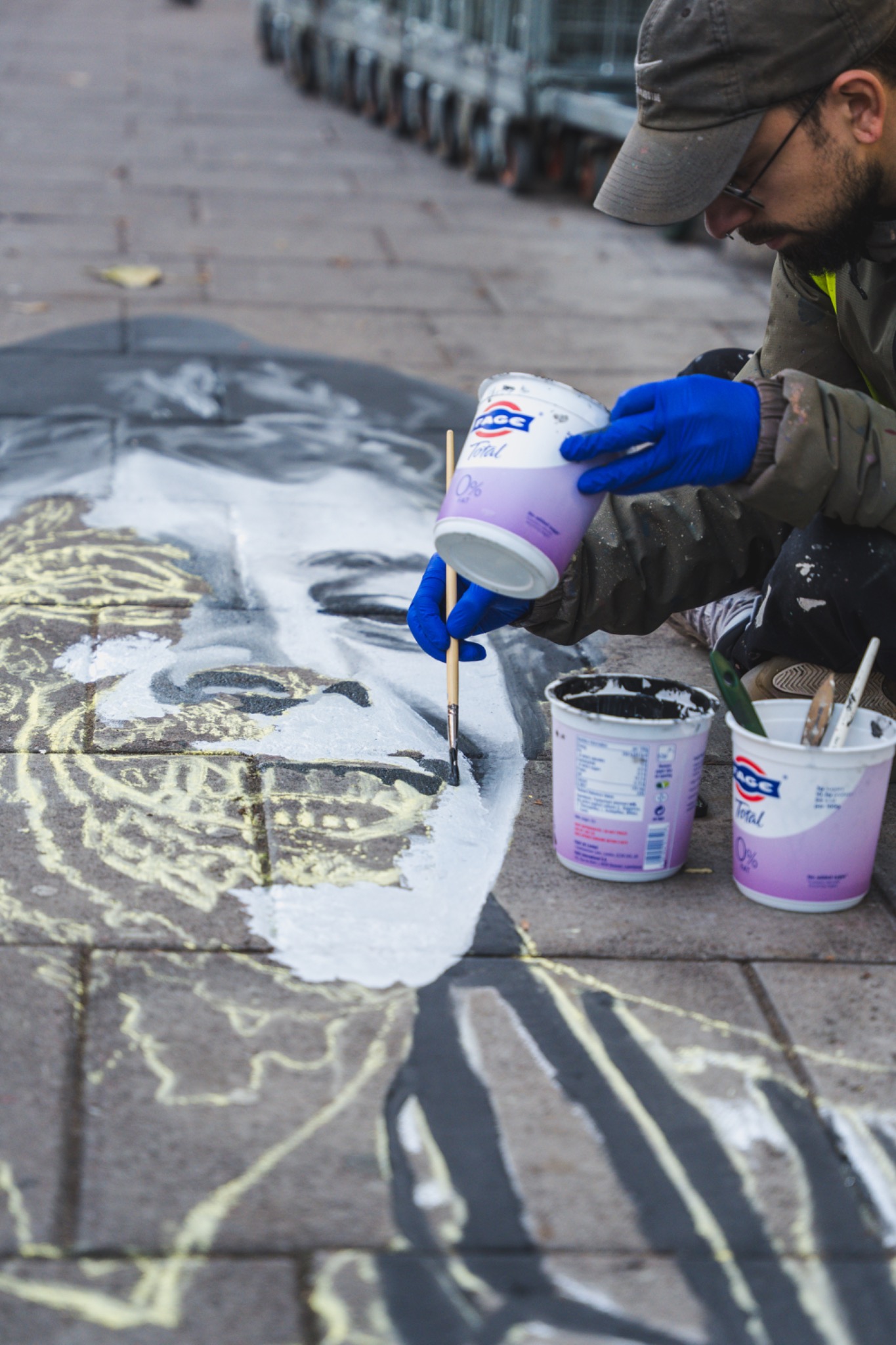 Artist working on chalk pavement artwork